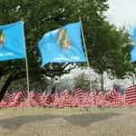 Rows of American flags with waving Oklahoma state flags in front.