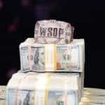 A World Series of Poker bracelet sits on a huge pile of cash.