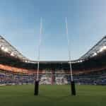 Two rugby goal posts in a large stadium.