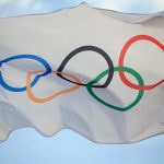 The Olympic flag flutters in the wind.